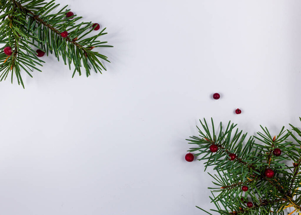 Рождественские украшения фон ели ели и красной ягоды на белом фоне. Шаблон открытки. Концепция подарочных карт на Новый год и Рождество. - Фото, изображение