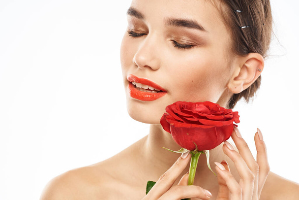 чарівна брюнетка дівчина з макіяжем на обличчі і червона троянда в руці
 - Фото, зображення