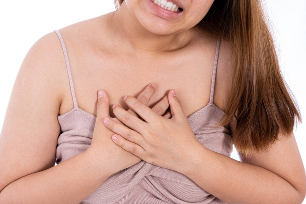 Nainen koskettaa sydäntään tai rintaansa eristetty valkoinen tausta. Terveydenhuollon lääketieteellisen tai jokapäiväisen elämän käsite. - Valokuva, kuva