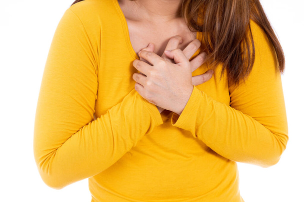 Frau berührt ihr Herz oder ihre Brust isoliert weißen Hintergrund. Gesundheitswesen medizinisches oder tägliches Lebenskonzept. - Foto, Bild