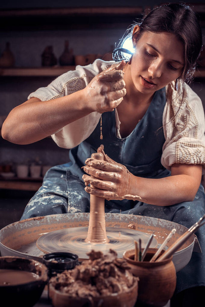 Schöne Kunsthandwerker machen Keramiktopf auf der Töpferscheibe. Kunsthandwerk. - Foto, Bild