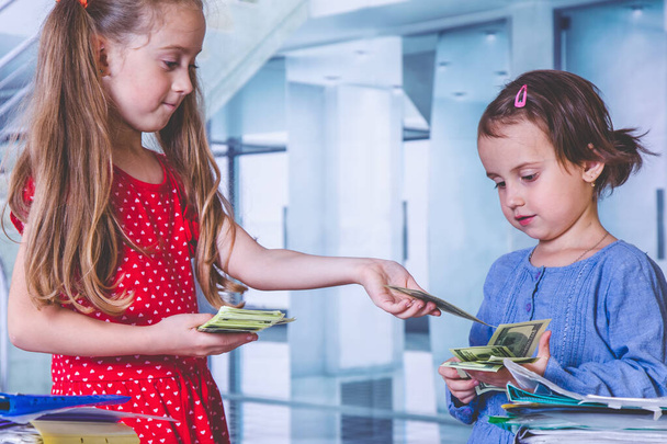 Vtipná fotka dvou obchodních dívek s bankovkami v amerických dolarech jako symbol úplatku v obálce. - Fotografie, Obrázek