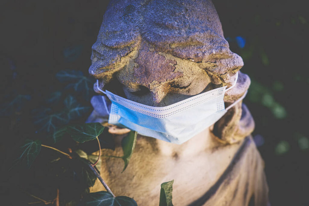 Egy közeli angyal orvosi maszkot visel. Coronavirus, légszennyezés pm2.5, és karantén koncepció. Vízszintes kép. - Fotó, kép