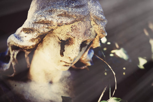 Egy ősi síró angyal szobor töredéke, könnyekkel az arcán, mint az emberi élet végét szimbolizálja. Közelről. Szelektív szemfókusz. - Fotó, kép