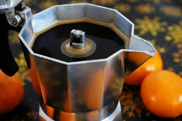 Italiaanse espresso koffiezetapparaat moka pot in kerstcompositie met mandarijnen closeup - Foto, afbeelding