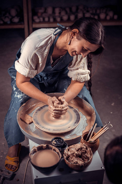 Charming ceramist master at his wheel creating a new masterpiece. Concept for woman in freelance, business, hobby. - Photo, Image