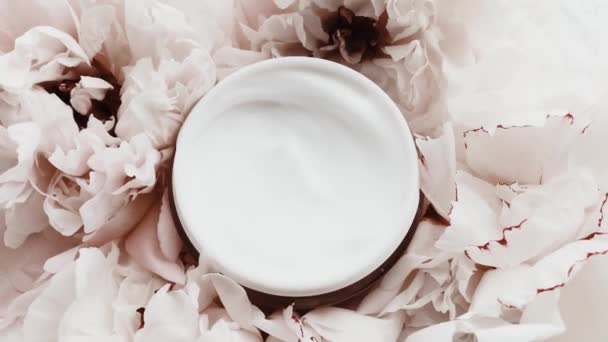 Anti-aging gezichtscrème pot en pioenroos bloemen, schone vochtinbrengende crème als huidverzorging routine voor luxe cosmetische, beauty product en huidverzorgingsmerk - Video