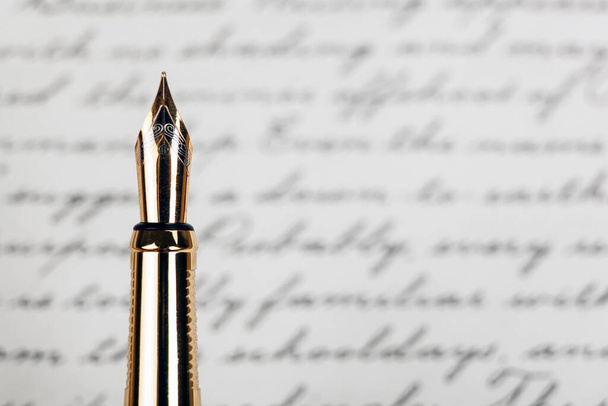 golden fountain pen with ink text background closeup - Photo, Image