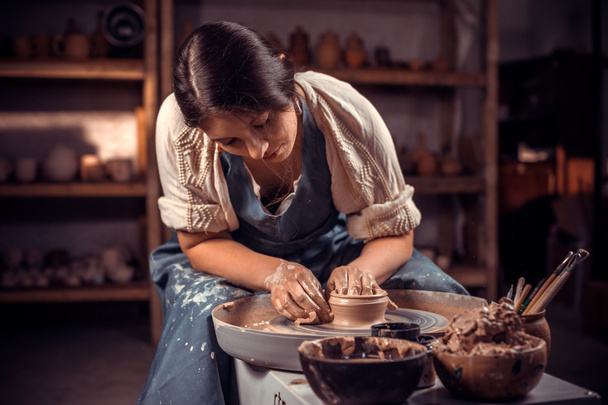 Stijlvolle jonge dame demonstreert het proces van het maken van keramische gerechten met behulp van de oude technologie. Ambachten. - Foto, afbeelding