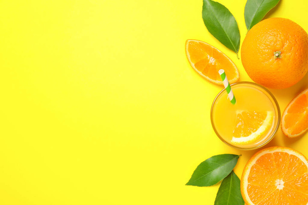 Glass of orange juice and fresh fruits on yellow background, flat lay. Space for text - Foto, afbeelding