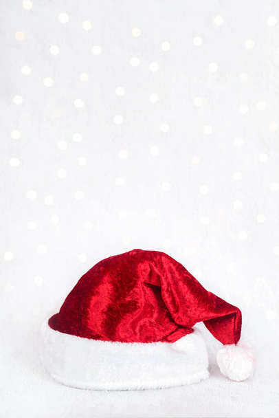 メリークリスマスクリスマスの光の上に隔離された赤いサンタの帽子。クリスマスのコンセプトの背景 - 写真・画像