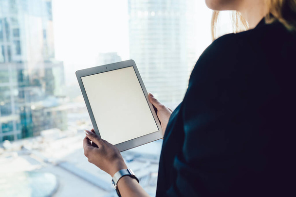 Cropped back view of female with modern digital tablet with copy space area for internet advertising, selective focus on hands holding mockup touch pad with blank screen for your web publication - Fotografie, Obrázek