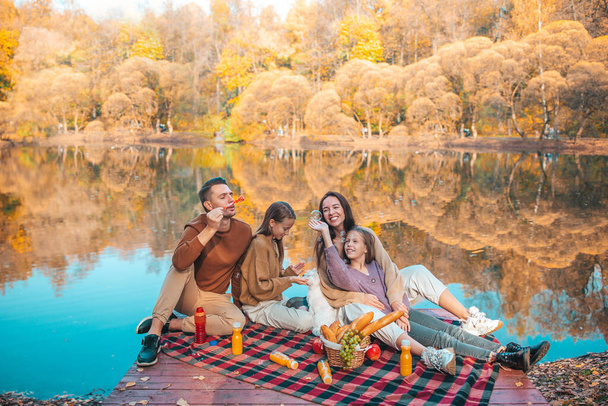 Ευτυχισμένη οικογένεια σε πικνίκ στο πάρκο το φθινόπωρο - Φωτογραφία, εικόνα