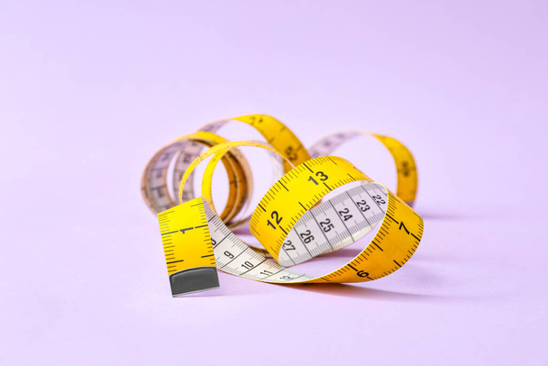 New measuring tape on violet background, closeup - Photo, Image