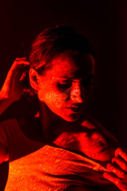 Creative portrait of a woman illuminated with colored lights on dark background. - Valokuva, kuva