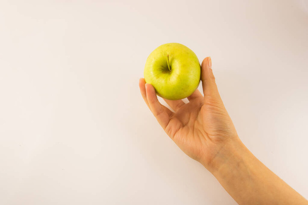 Держите яблоко в руке на белом фоне - Фото, изображение
