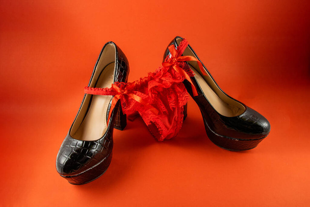 Heeled shoes with red panties on a red background - Φωτογραφία, εικόνα