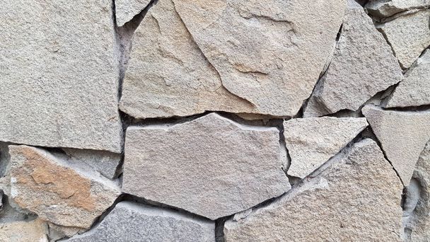 Rough stone mosaic textured background. Brickwork backdrop. Stone masonry wall surface closeup - Photo, Image