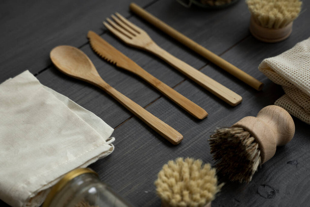 Zero waste kit. Set of eco friendly bamboo cutlery and cleaning brushes, mesh cotton bags and glass jars. Plastic free. Natural and reusable items accessories on wooden table surface. - 写真・画像