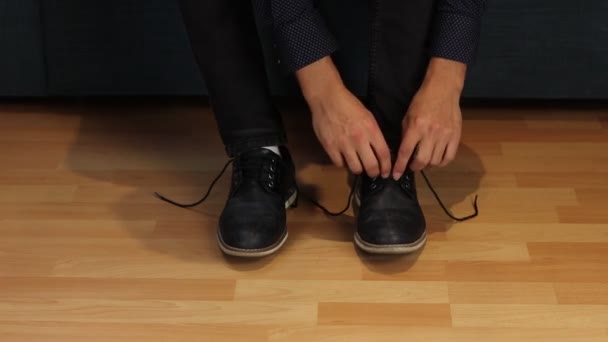 Osoitus siitä, miten sitoa kengät oikein. Nuori luova mies näyttää lapsille, miten tehdä oikein jousi kengilleen. Yksi perus-ja intuitiivinen liikkeitä. Video laukaus Full HD 60 fps. - Materiaali, video