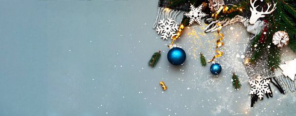 Ünnepi szürke háttér csillogással. Karácsonyi fabábuk fenyőágakon. Kreatív fénymásolás. Közelkép - Fotó, kép