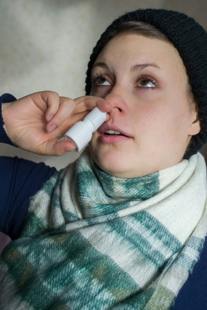 Girl sprays the spray from runny nose into the nasal pass - Zdjęcie, obraz