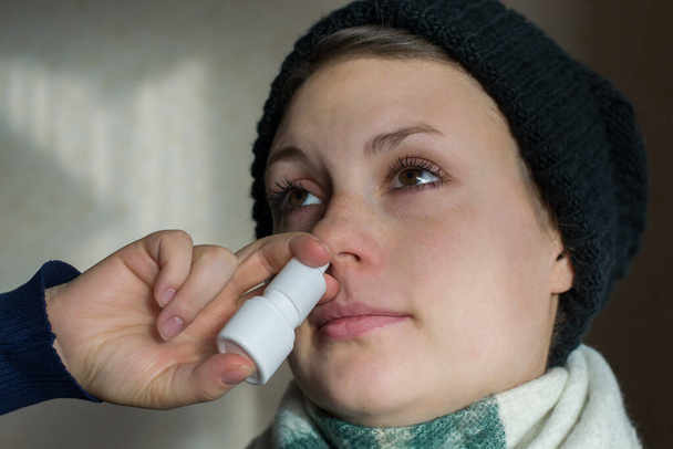 Mädchen sprüht Spray aus laufender Nase in die Nase - Foto, Bild