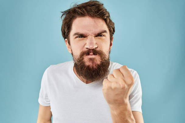 Homme avec expression faciale mécontente geste avec les mains studio style de vie fond bleu - Photo, image