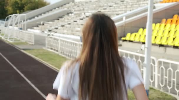 Подальший знімок молодого бігуна з фітнесу в спортивному одязі, що працює на трасі стадіону
 - Кадри, відео