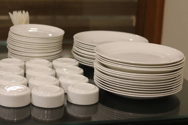 kerámia tányérok és tálak gondoskodnak asztalra étterem ebédlőben - Fotó, kép