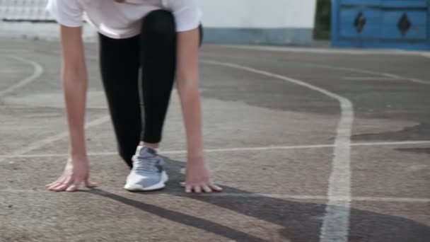 slim fit asiático corredor em sportswear começa a correr de bloco na pista de estádio - Filmagem, Vídeo