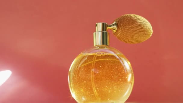 Złota butelka perfum i błyszczące lekkie flary, elegancki zapach jako luksusowy produkt dla marki kosmetycznej i kosmetycznej  - Materiał filmowy, wideo