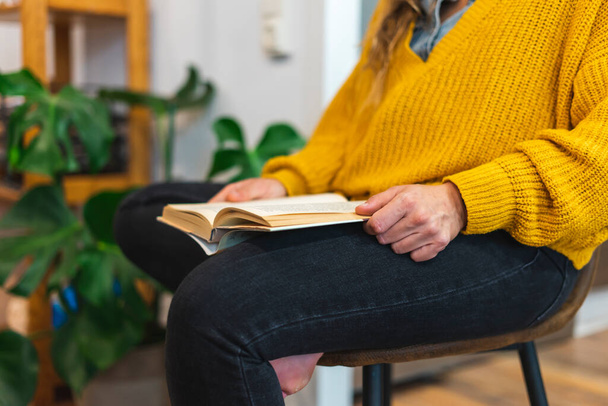 Jovem mulher lendo um livro em uma cadeira - Foto, Imagem