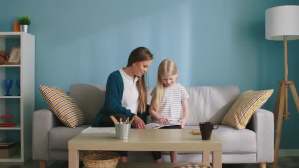 Mutter und Mädchen schließen Freundschaft beim gemeinsamen Lesen - Filmmaterial, Video
