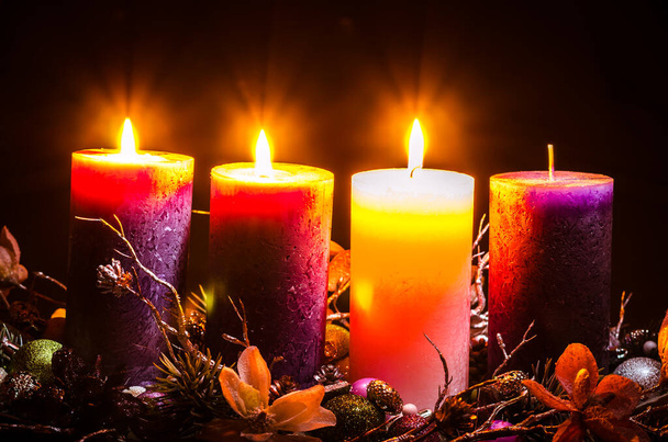 candele rosa e viola nella decorazione della corona d'avvento su sfondo nero - Foto, immagini