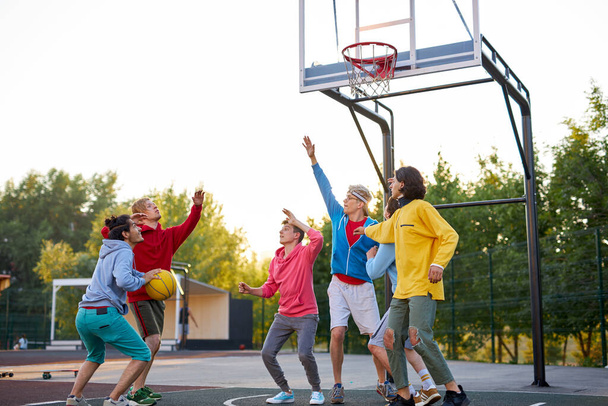 group of young male teenagers playing basketball outdoors - Foto, immagini