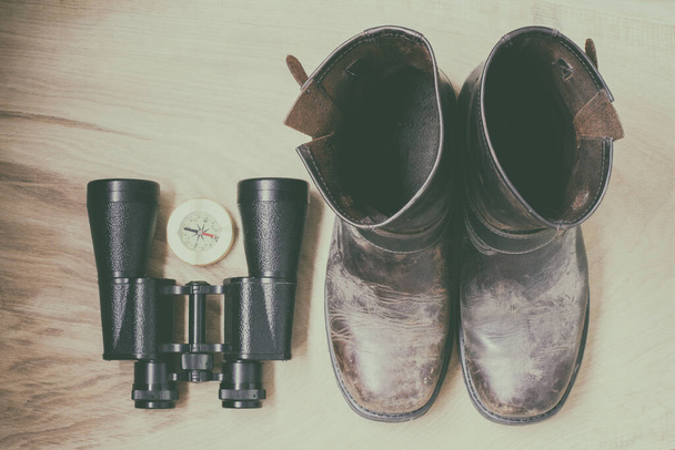 Lornetka, buty i kompas, rzeczy podróżne, na drewnianym tle - Zdjęcie, obraz