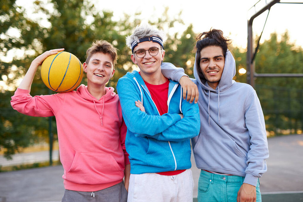 portrait of cheerful teenagers boys at basketball playground - Foto, Imagen