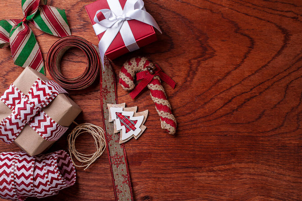 Kompozycja świąteczna na drewnianym tle z wstążkami i prezentami.Widok z góry. Przestrzeń kopiowania - Zdjęcie, obraz