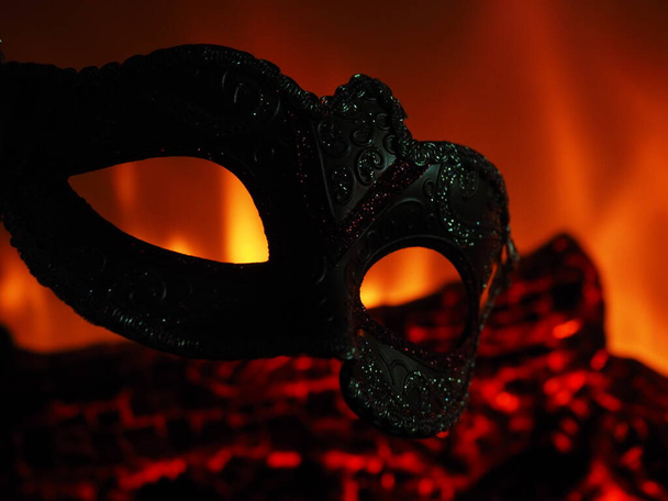 Μάσκα στο φόντο του τζακιού στο σκοτάδι - Φωτογραφία, εικόνα