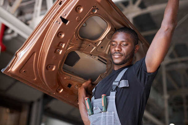 afro american auto mechanic is going to change seperate part of automobile - Photo, image