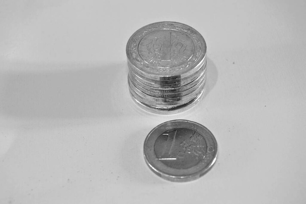 Geld und Währung der Türkei. Geld und Gruppen von "Eine Türkische Lira" -Münzen zusammen und 1-Euro-Münzen. Isolierter Hintergrund. Schwarz-Weiß-Foto - Foto, Bild