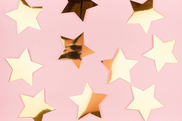 Modern festive background with golden shimmer stars on soft light pink background, pattern. - 写真・画像