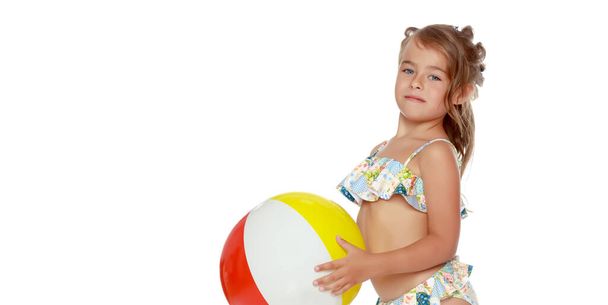 Little girl in a swimsuit with a ball. Childrens emotions concept. - Foto, Imagen