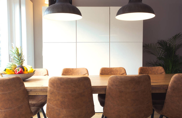 Tavolo moderno in legno con set di sedie alla moda, pianta d'appartamento, frutta in sala da pranzo retrò, nuova casa di design d'interni - Foto, immagini