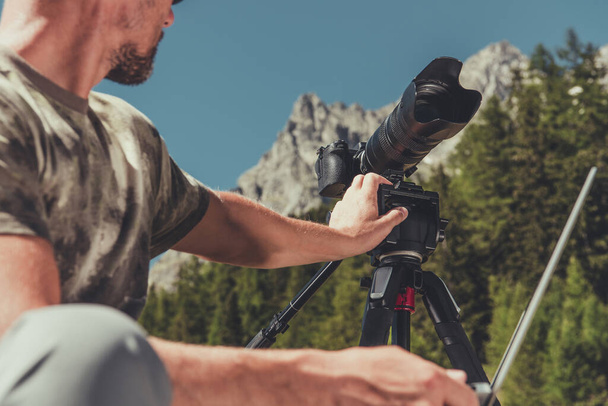 40代の白人写真家が風景山の風景写真撮影のためのカメラ機器を準備. - 写真・画像