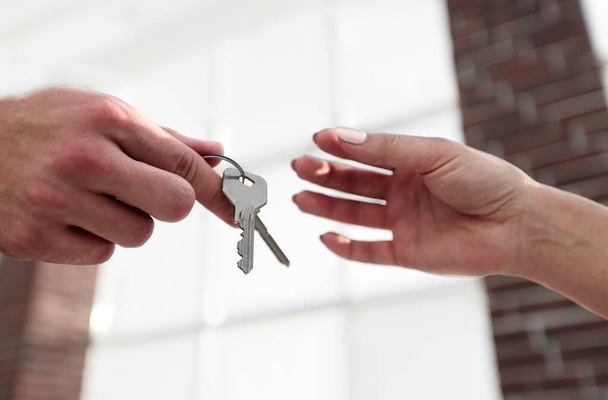 Vágott kép ingatlan ügynök ad ház kulcsát, hogy az ember az irodában - Fotó, kép