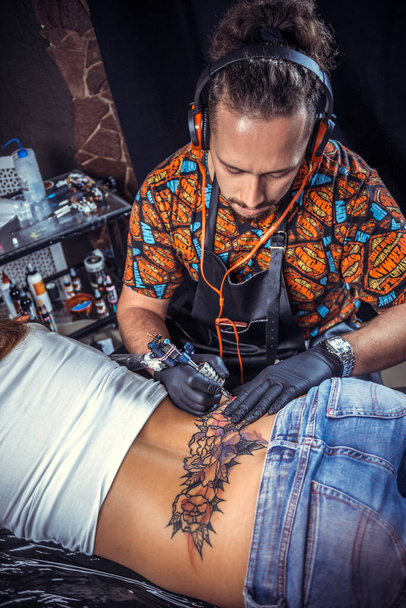 Tatuaje artista trabaja en salón de tatoo - Foto, imagen