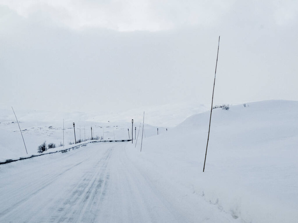 Driving through snowy white road and landscape in Norway. - 写真・画像