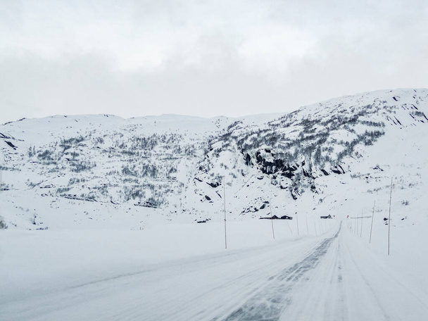 Driving through snowy white road and landscape in Norway. - Foto, imagen